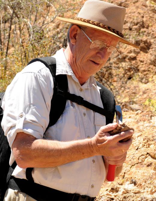 A mining geologist collects and studies rock samples to determine the quality of the minerals.