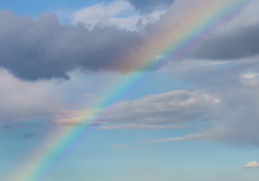 Water droplets in the atmosphere act like prisms when they bend, or refract, light and create a rainbow.