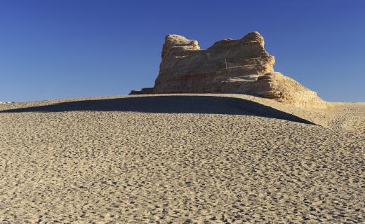 A structural field geologist specializes in the formation of rock structures, such as how wind erosion shaped a desert yardang.